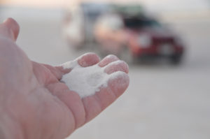 The winds pick up the crystals and the bump against each other, breaking into smaller pieces, and getting scratched up so that they are no longer clear.